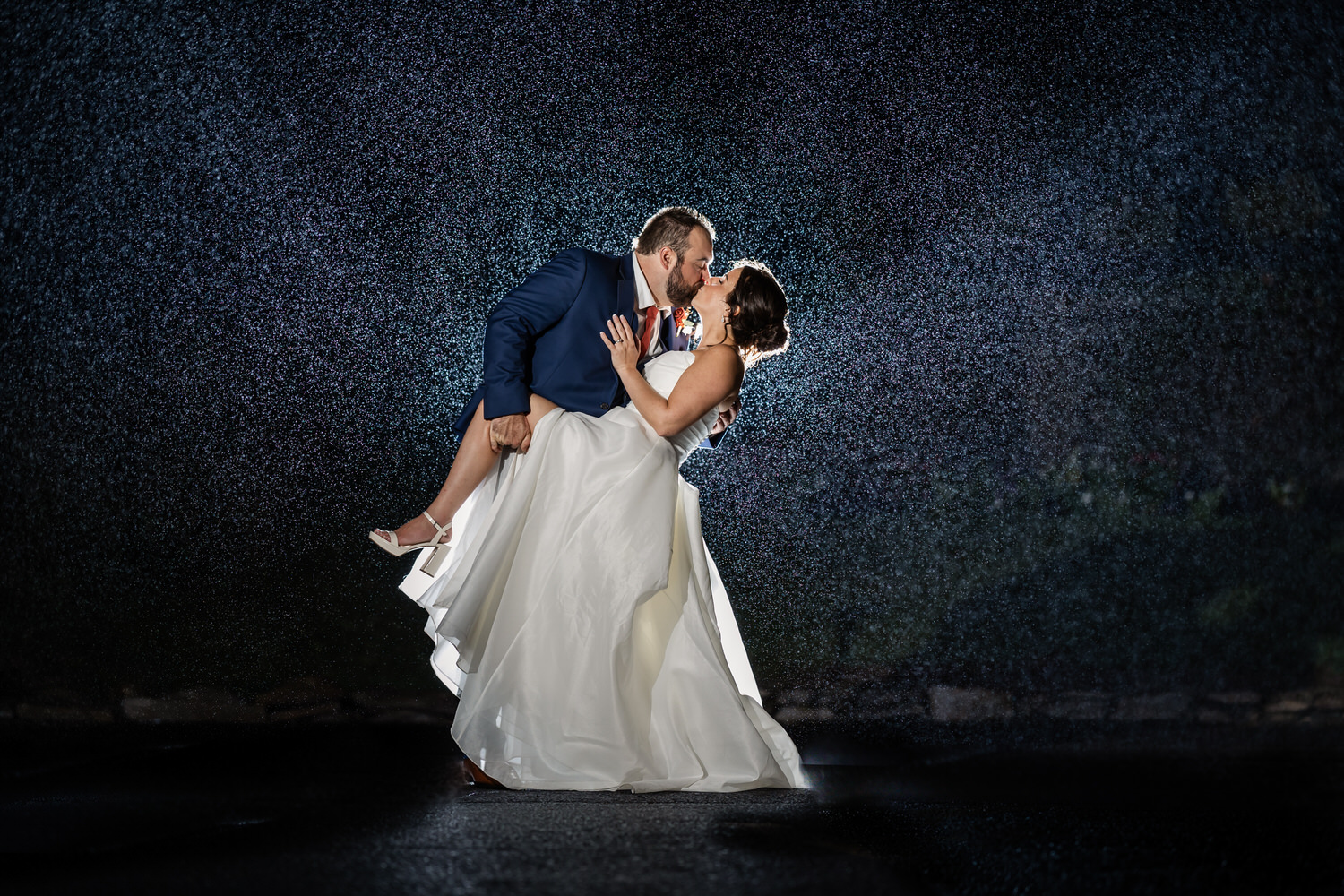 bride and groom dipping in the rain